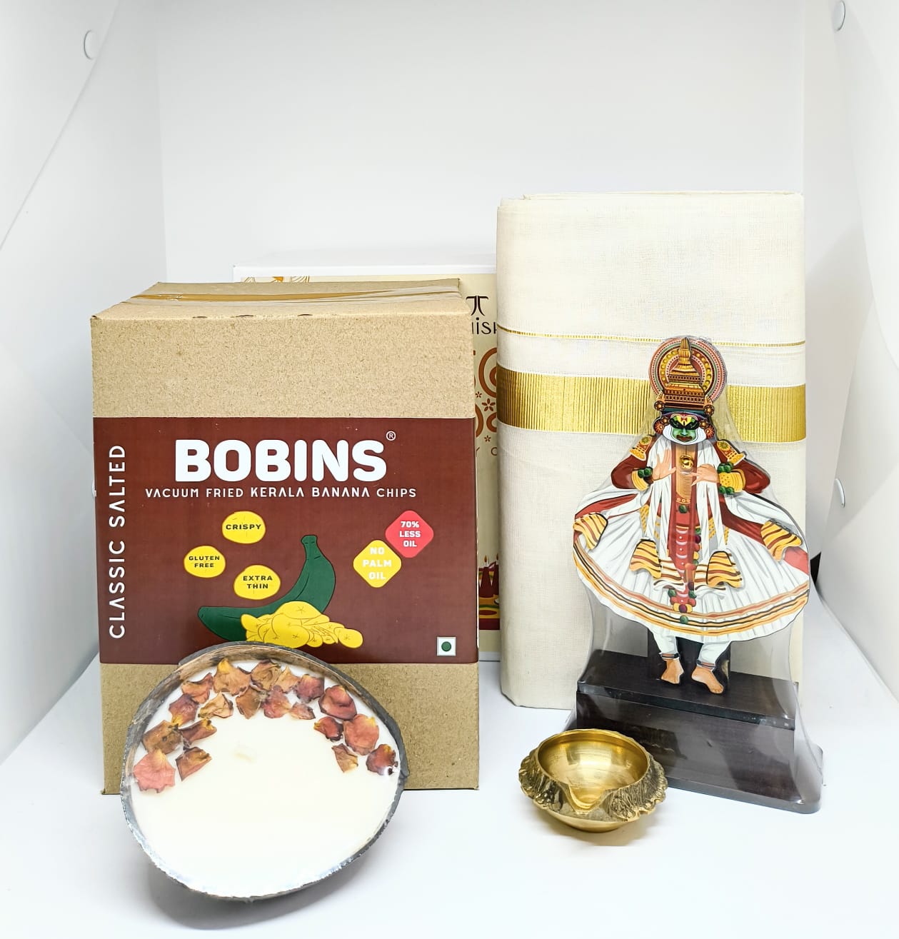 Kerala Onam Hamper – Kathakali Full Body Stand, Brass Diya, Coconut Candle, Kasavu Mundu & Snacks
